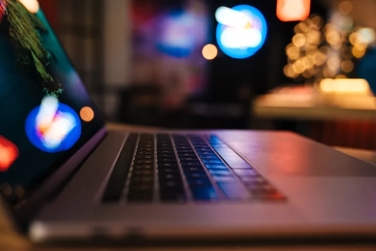 Zbliżenie klawiatury laptopa w wieczornym świetle neonów